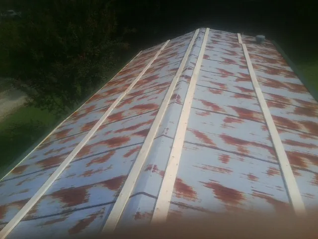 Rusted metal roof panels with new wood purlins before replacement — Storm Damage Roof Repair in Pandora by Roofing Brothers