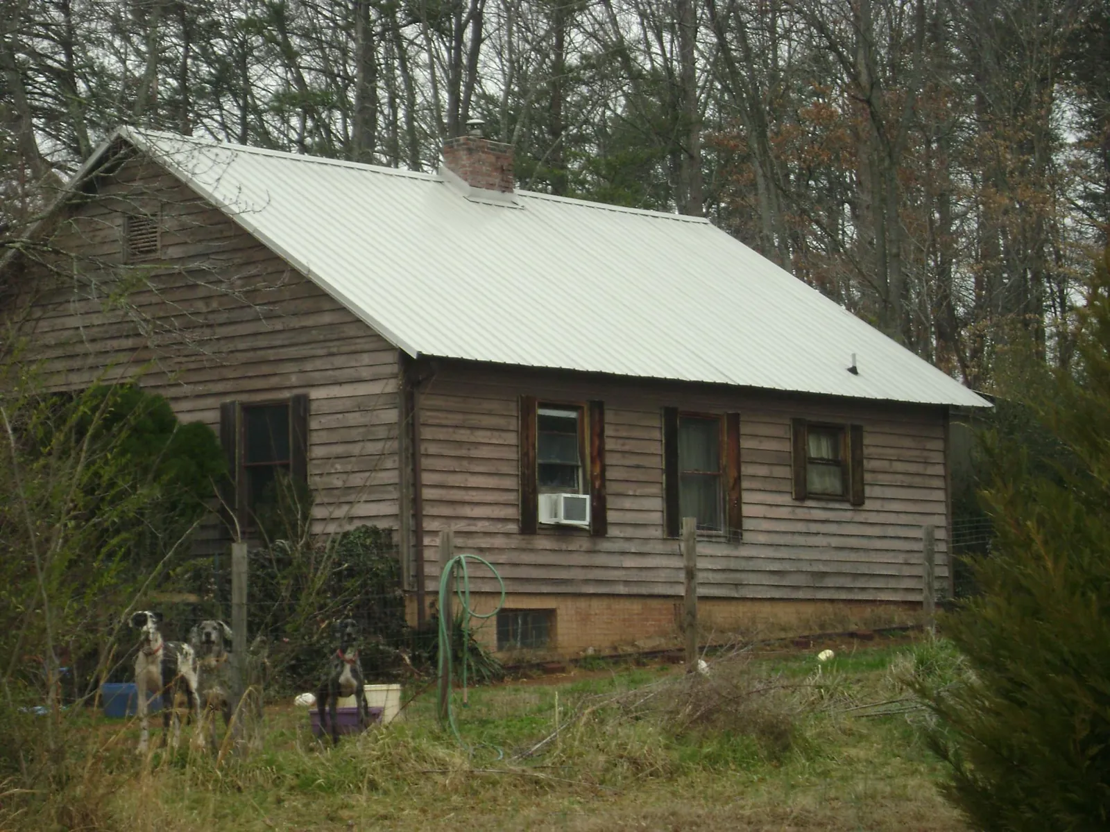 White metal roof on an old wood sided farmhouse, from a Metal Roof Installation job in Pandora